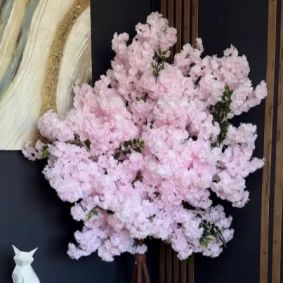 A decorative indoor tree covered in realistic pink cherry blossoms made from foamiran material