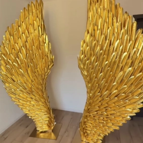 Large-scale ornate golden wings prop created from textured EVA foam for photo shoots or events